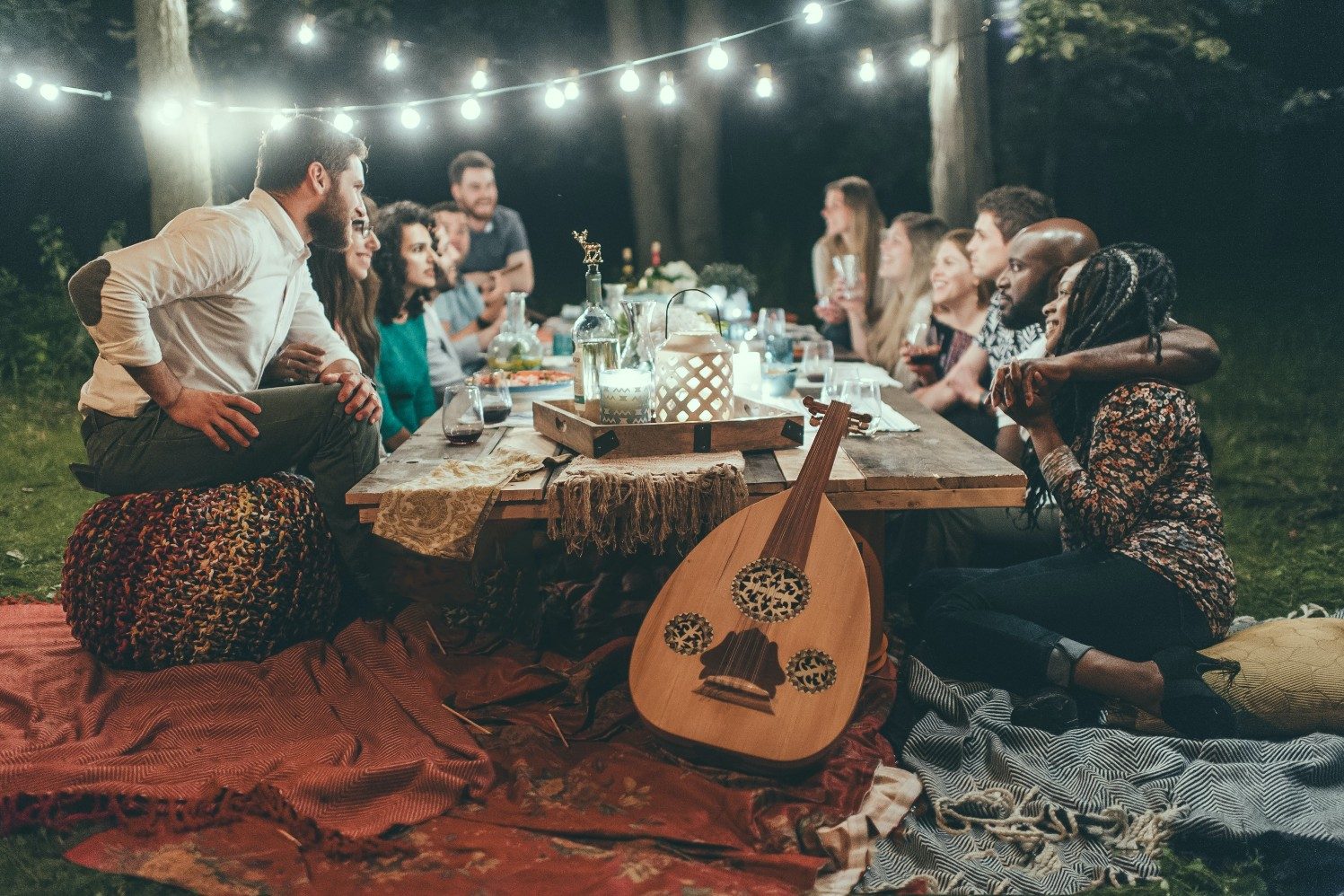 group of people sitting around a table in an outdoor space