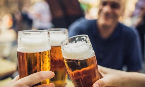 Three friends cheering with glasses of pilsner beer