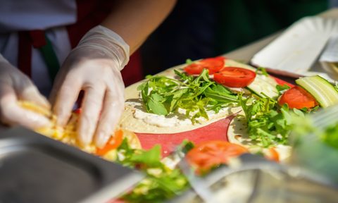 Close-up of hands of cook in gloves preparing fajitas, tortilla.