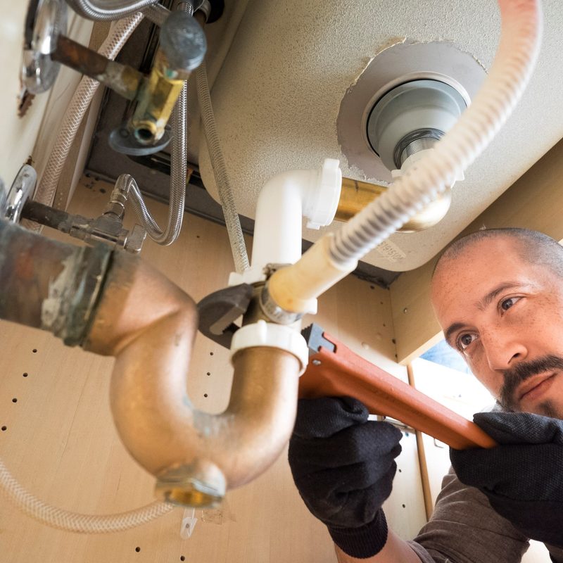 Plumber working under a kitchen sink