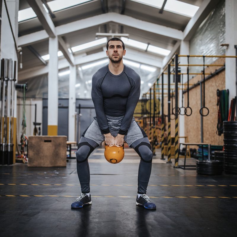 Man doing kettlebell swings