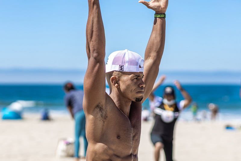 Fitness trainer and pro Kupah James demonstrating a simple back workout at the beach