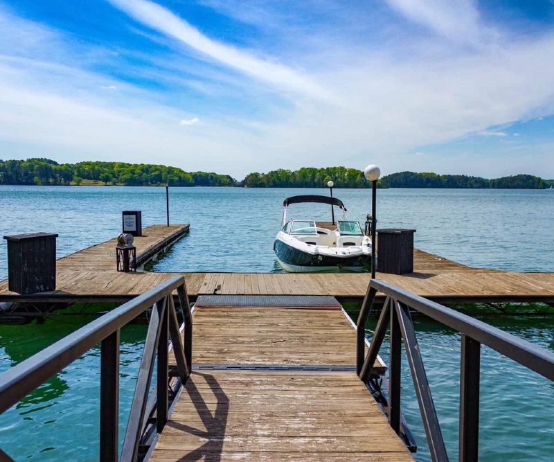 Boardwalk and a boat on Lake Lanier during daytime