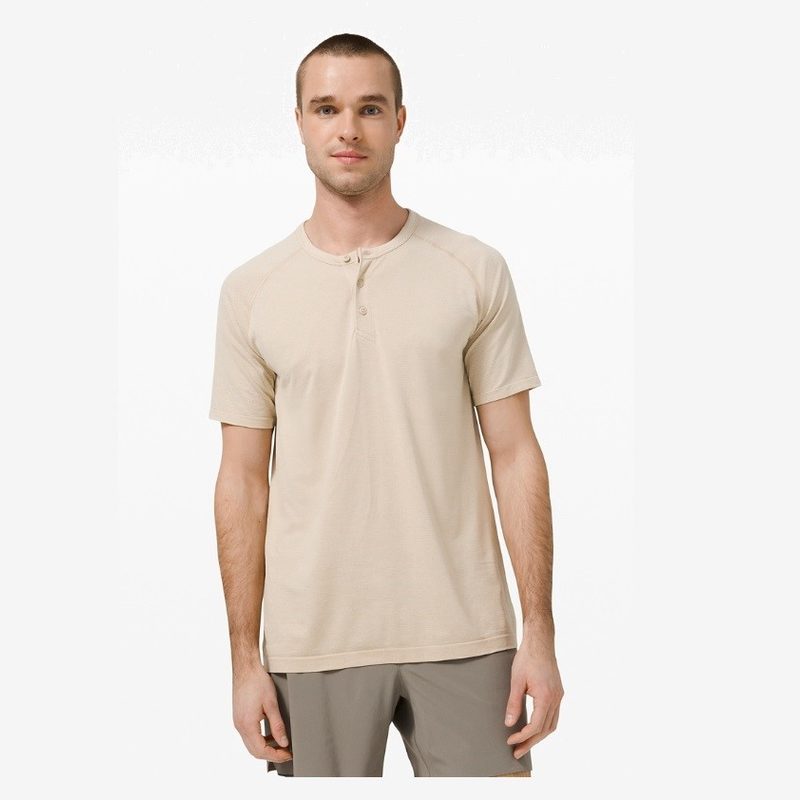 man wearing a cream colored short sleeved henley shirt.