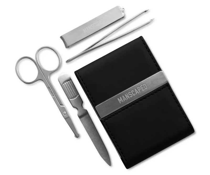 Tweezers, scissors, nail clippers, and a medium grit file beside a travel case.