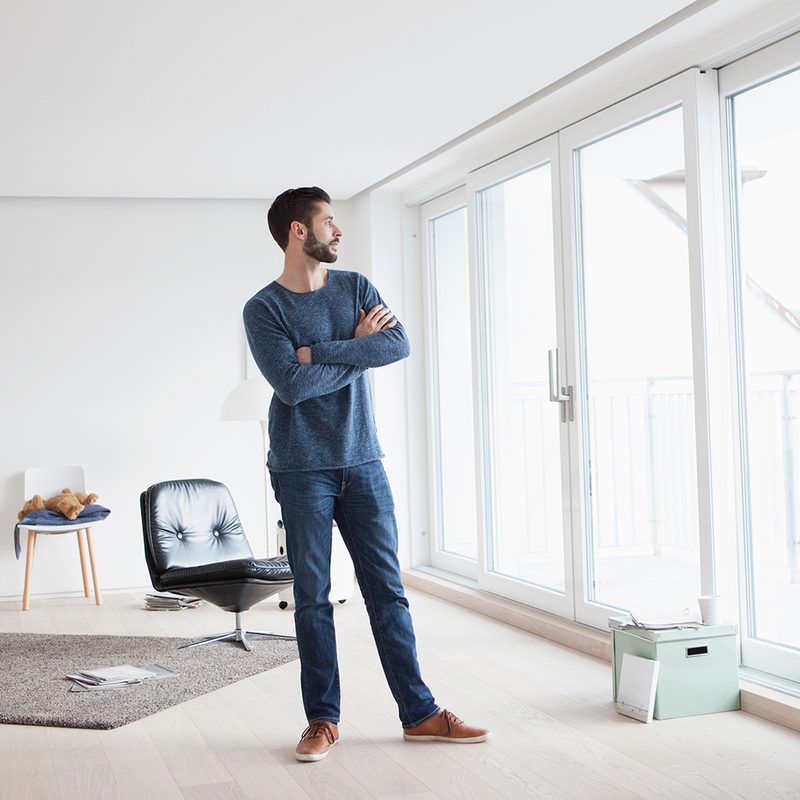 A man looking outside of his minimalist home.