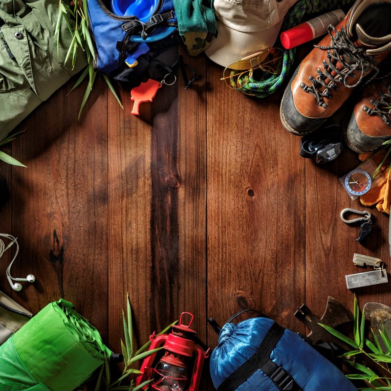 Overhead shot of hiking gear laid out in a circle on a wood surface.