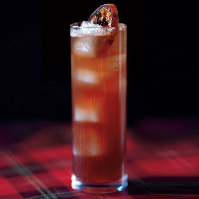 An ice-cold glass of Red Tartan on checkered tablecloth.