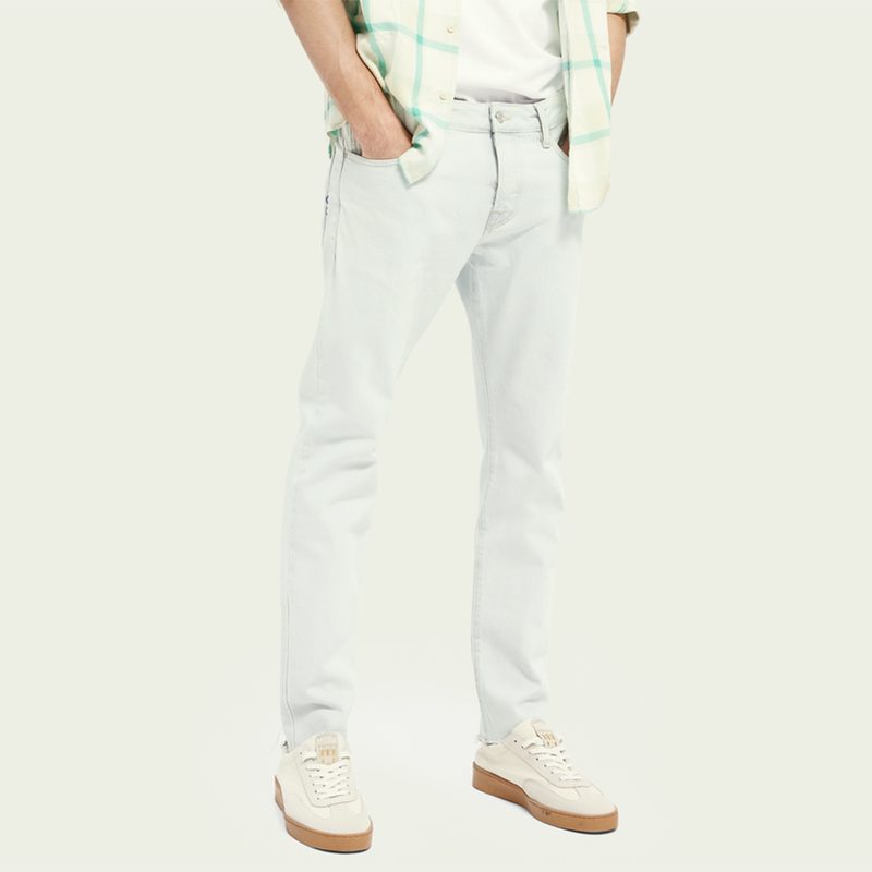 Scotch & Soda Ralston Cropped Organic Cotton Jeans with green, patterned shirt and sneakers.