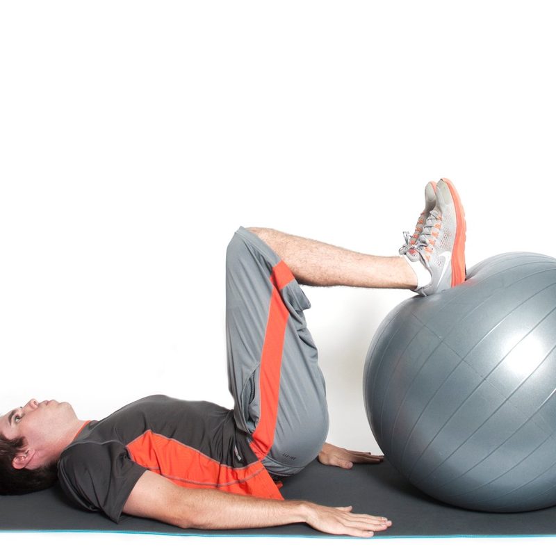 Man doing stability ball curls