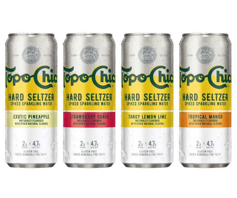 Various flavors of Topo Chico in line on a white background.