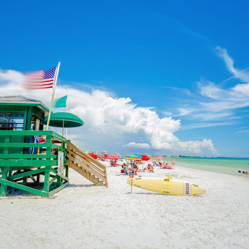 A lifeguard tower at Siesta Key beach in Sarasota, Florida with an American flag in the wind