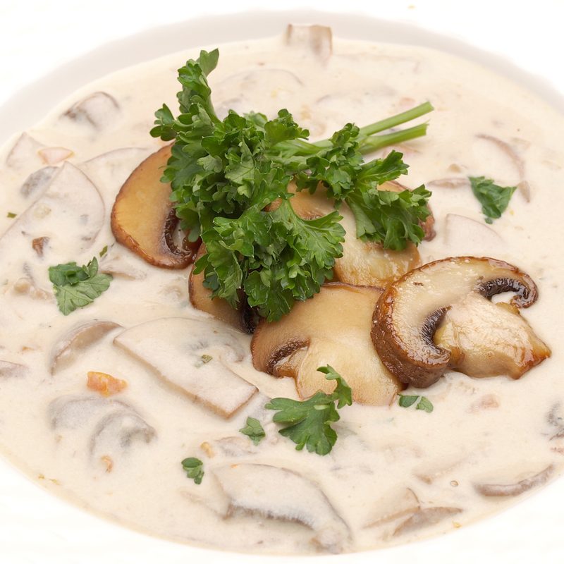 Bowl of cream of mushroom soup garnished with sauteed crimini mushrooms