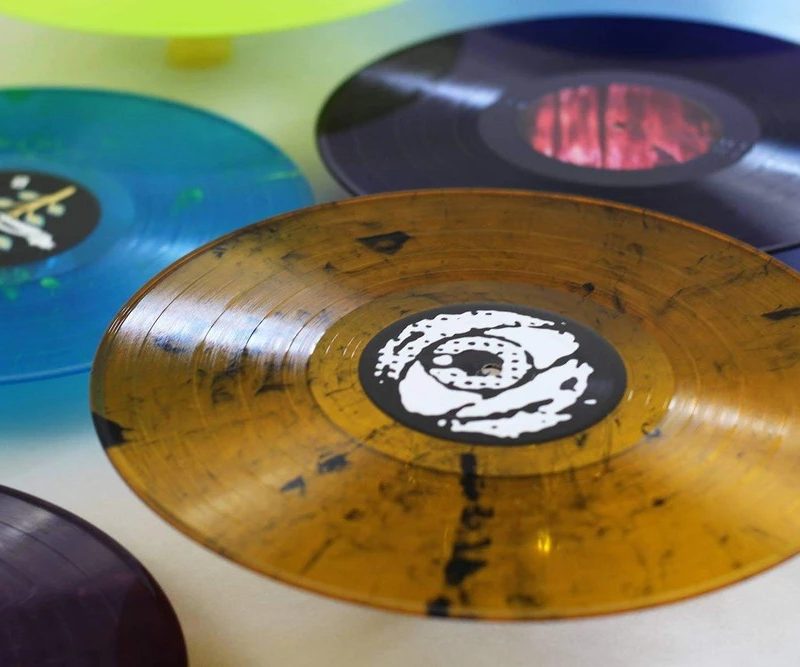 Vinyl records of various colors on a table.