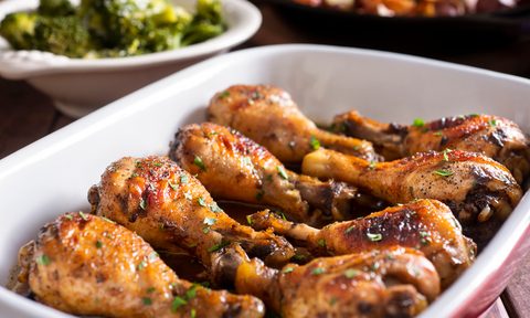 Marinated chicken legs in a baking dish with steamed broccoli and roasted potatoes
