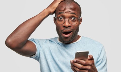 A surprised man holding his head.