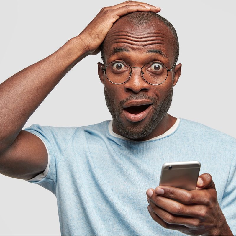 A surprised man holding his head.