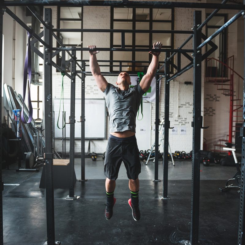 Man doing pull ups in the gym.