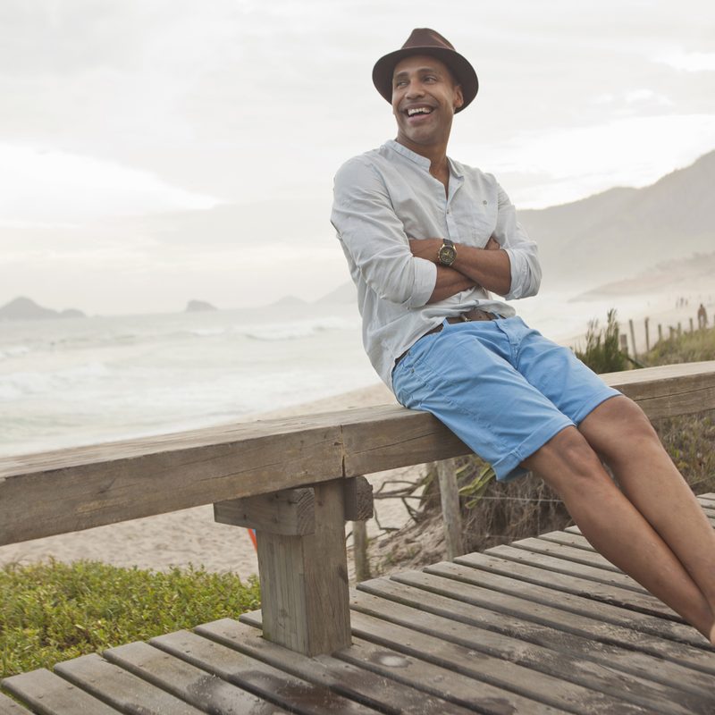 Man wearing a fedora hat and light blue chino shorts with flip-flops.