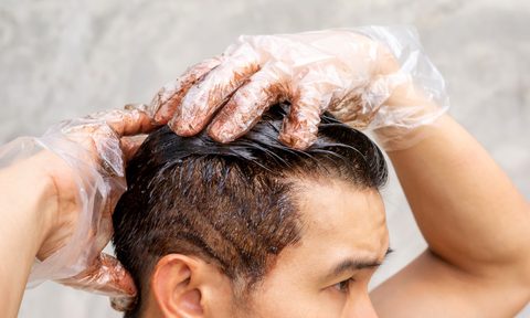 Many dyeing his hair with a gray background