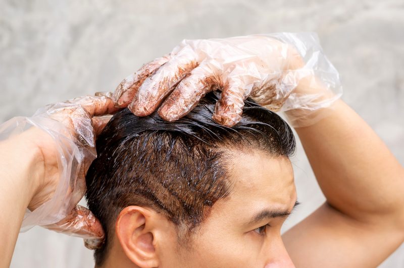 Many dyeing his hair with a gray background
