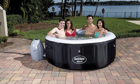 A group of people sit in a SaluSpa hot tub.