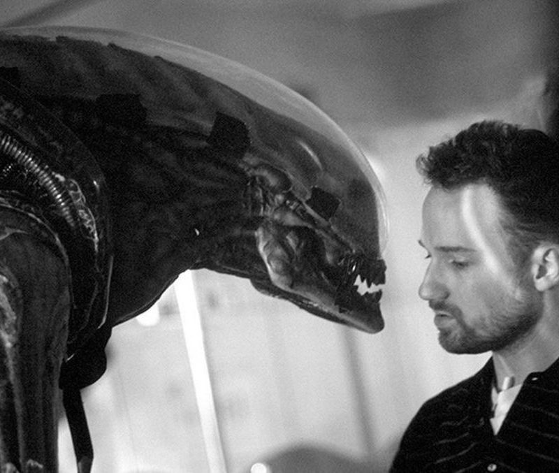 Black-and-white image of the creature from Alien staring at a man.