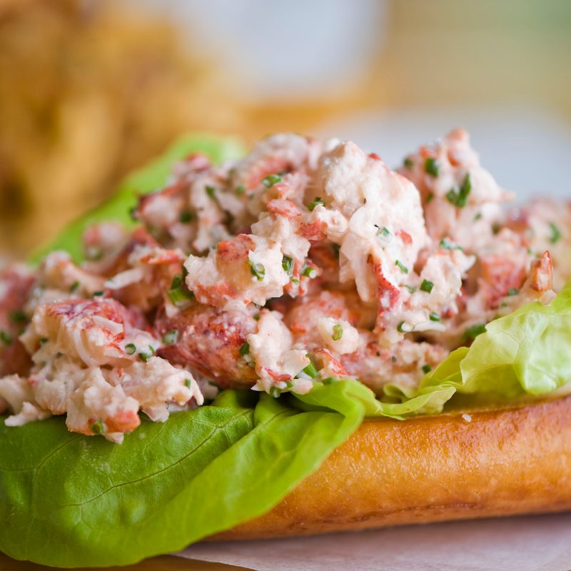 A lobster roll with a toasted bun, Bibb lettuce, and seasoned and dressed lobster meat.