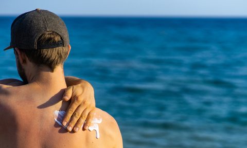 man putting on sunscreen