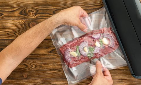 best cheap sous vide machine deals man sliding packaged meat into black ma