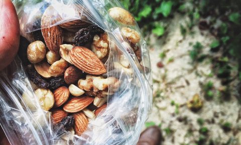 beginners guide to mountain running close up of hand holding trail mix
