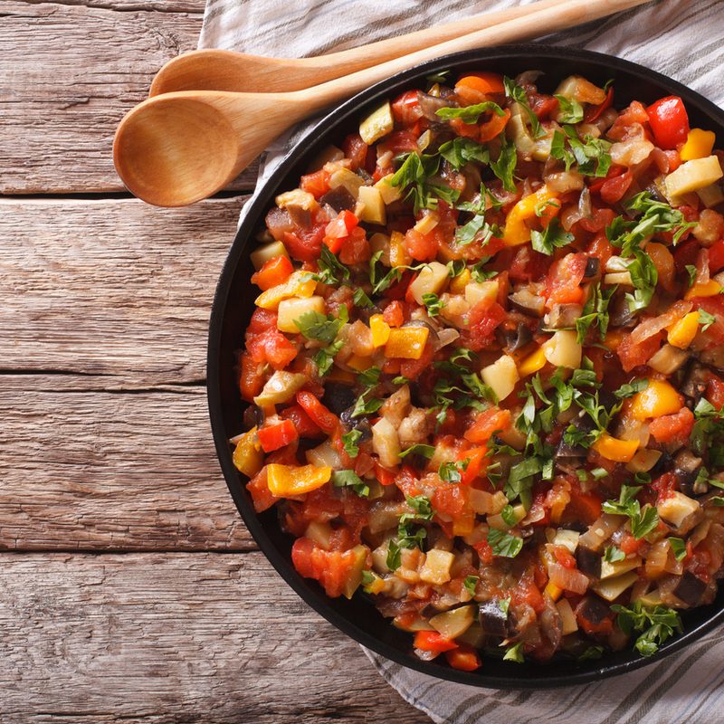 Ratatouille Provencale - Steamed vegetables: eggplant, peppers, tomatoes, zucchini, onion close-up on a plate on the table