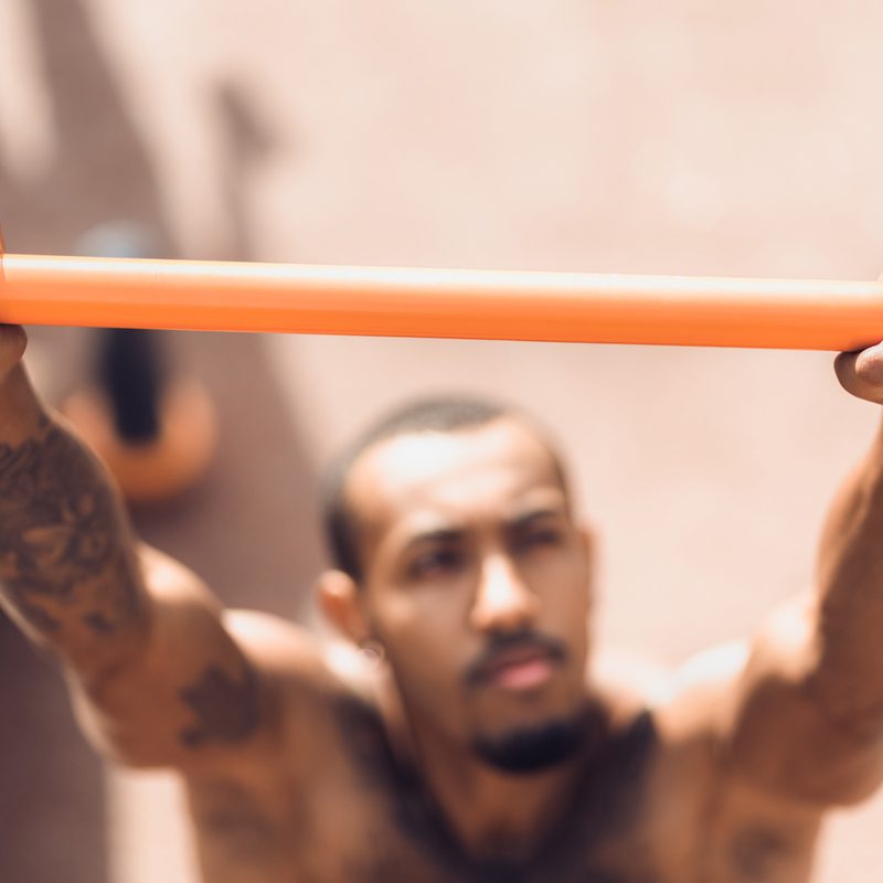 Male hands holding pull ups bar outdoors during workout