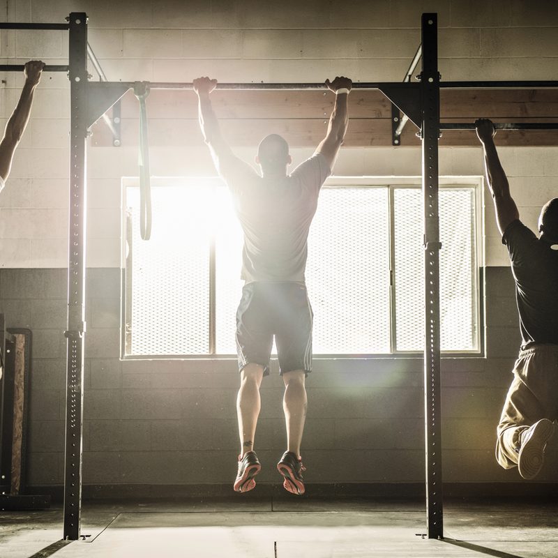 Men hanging from pull-up bars