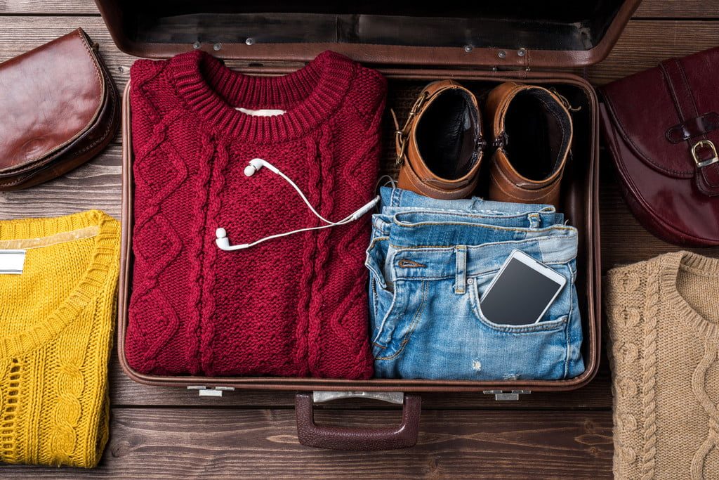 Suitcase with a sweater, jeans, and shoes