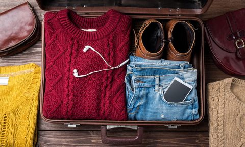 Suitcase with a sweater, jeans, and shoes
