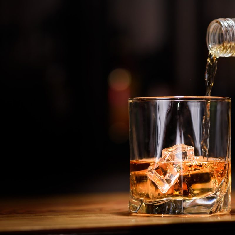 Still life. pour or whiskey in to glass.