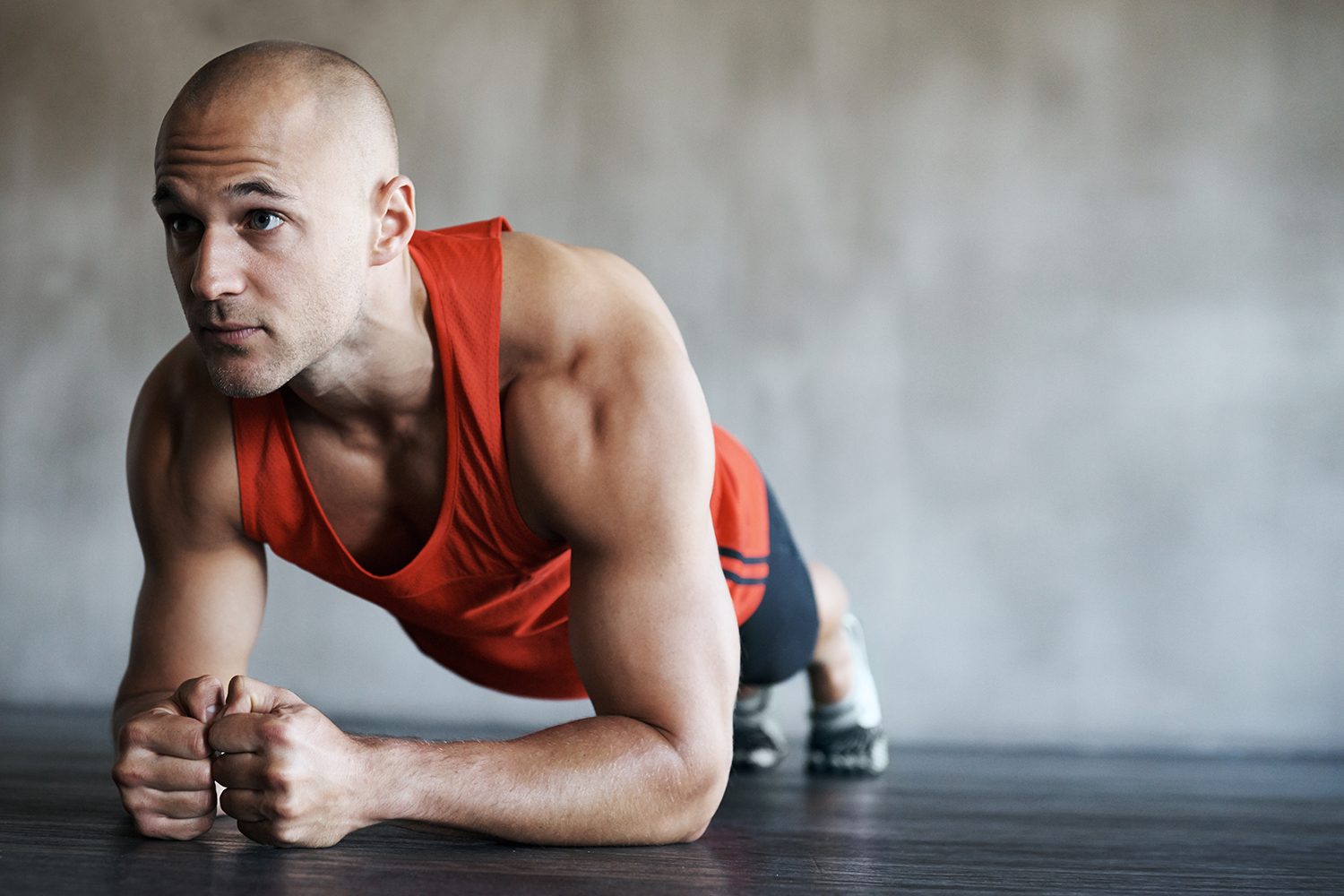 man in red sleeveless shirt doing plank pose