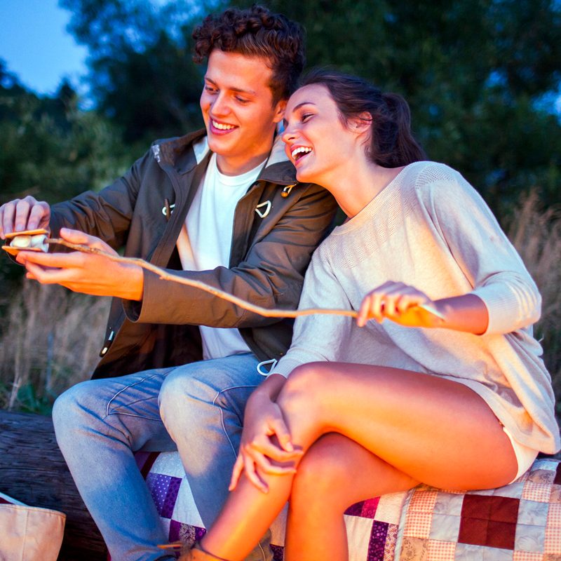 A couple making s'mores at night