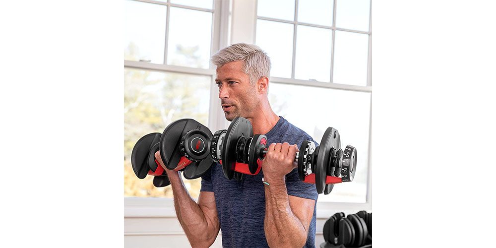 A man lifting Bowflex SelectTech adjustable dumbbells.