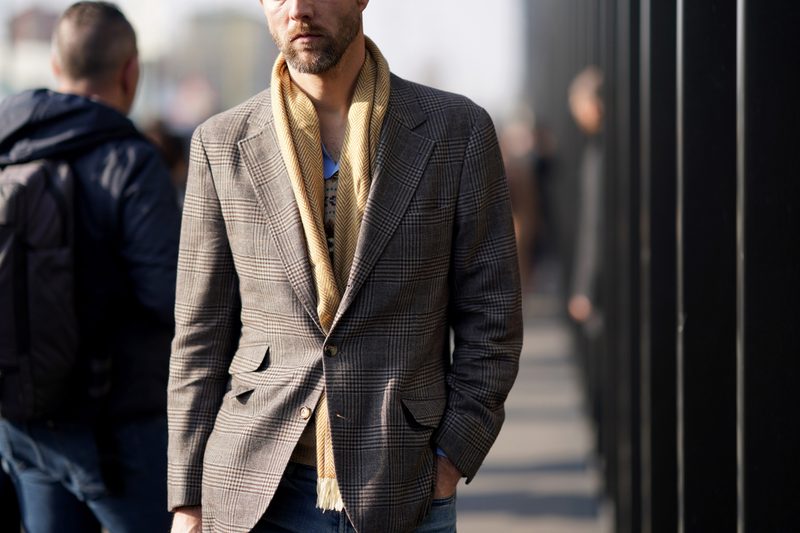 An midsection of a man wearing a checkered blazer.
