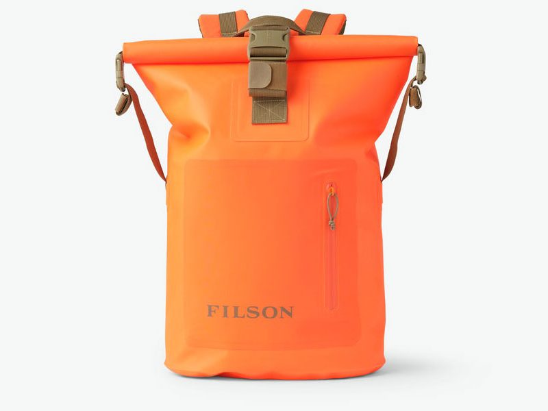 Bright orange Filson Dry Backpack on a white background.