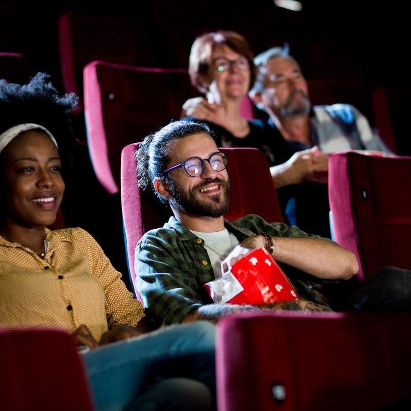 Young and old couples watching a movie in the cinema.