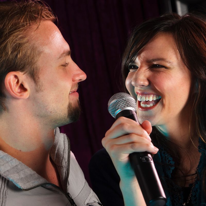 A man and a woman singing karaoke.