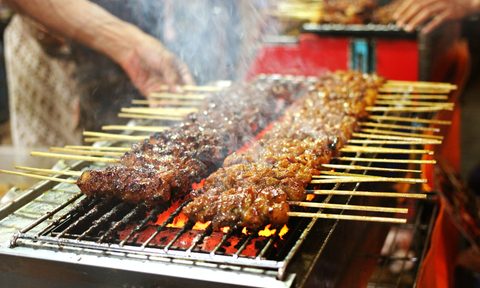 person flipping meat on grill