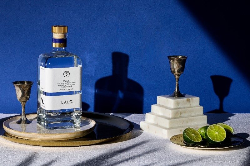 LALO tequila on a table with cut limes