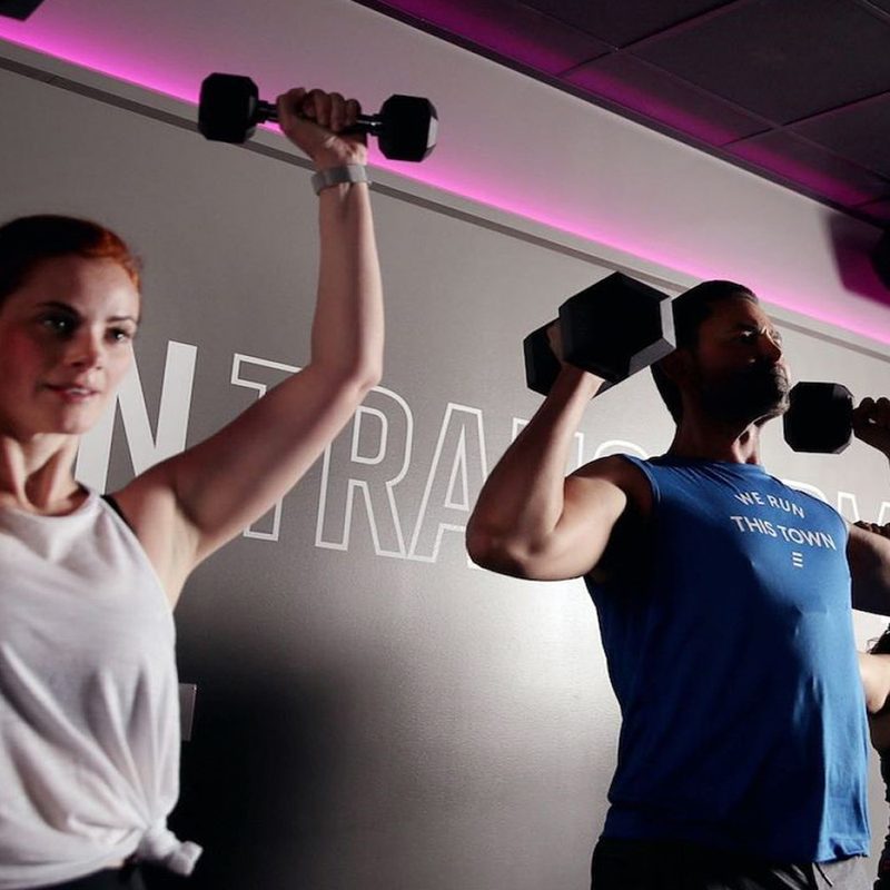 Three athletes lifting dumbbells at Stride Fitness