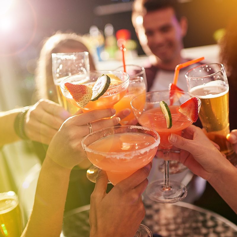 A group of people toasting with their drinks at a party.