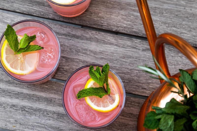 Three glasses of pink Picnic Basket Cocktail on a table.