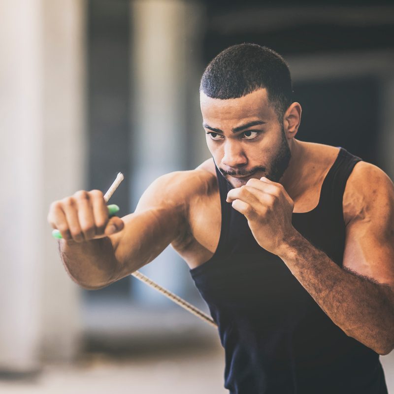 A man shadowboxing in a gym.